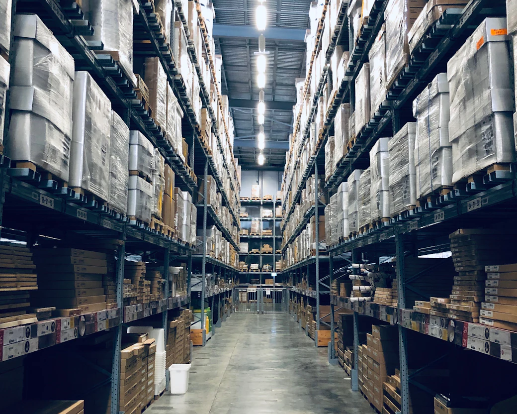 A warehouse aisle with shelves of boxed goods